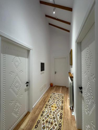 a hallway with white walls and a door with a rug at Chestnut Hill in Kolgecaj