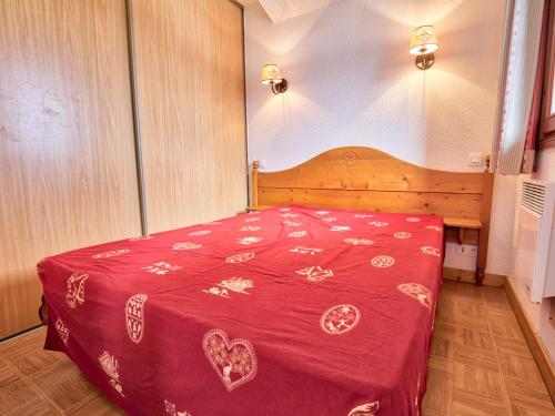 une chambre avec un lit avec une couverture rouge dans l'établissement Appartement cosy avec piscine, au pied des pistes, parfait pour 4 personnes - FR-1-505-112, à Flumet