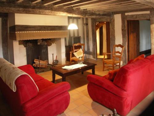 a living room with red furniture and a fireplace at Le bourrut in Luglon
