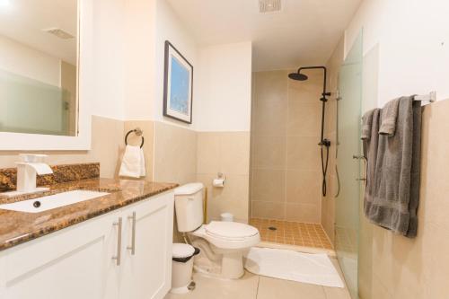 y baño con aseo y ducha. en Maho Beach Suite 2BR Lux Condo next to Morgan Resort en Maho Reef