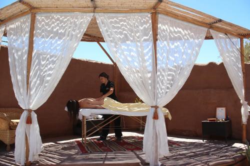 a woman is sitting on a bed in a tent at Hotel Kimal in San Pedro de Atacama