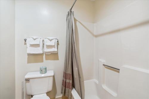 bagno bianco con servizi igienici e asciugamani di Cedarbrook Hotel Room 2 Doubles 119 a Killington