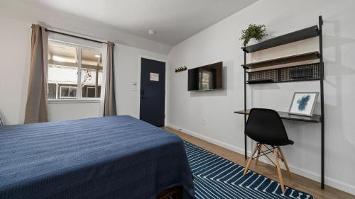 サウス・レイクタホにあるAdventure Lodgeのベッドルーム(青いベッド1台、椅子付)
