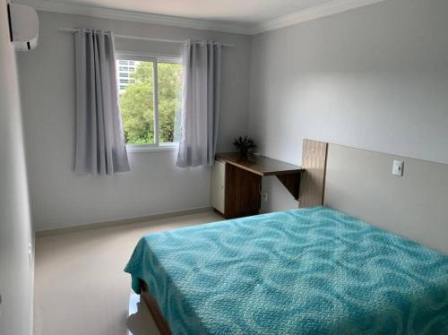 ein weißes Schlafzimmer mit einem Bett und einem Fenster in der Unterkunft Lindo Apto NOVO na Avenida, climatizado e aconchegante in Piratuba