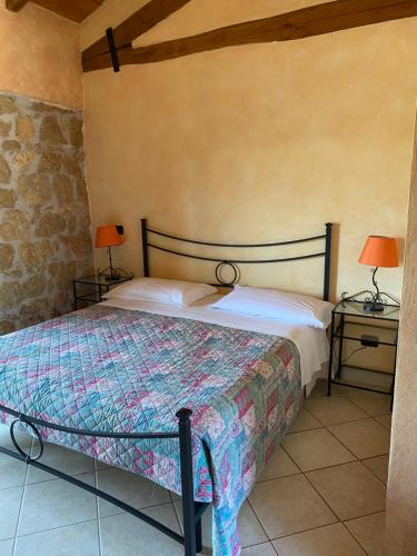 a bedroom with a bed and two tables with lamps at La fattoria di Carlotta in Maenza