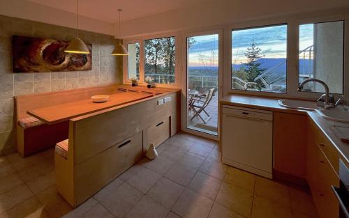 a kitchen with a counter with a sink and windows at Casa Blanco in Cercedilla