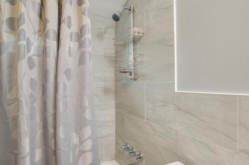 a shower with a white shower curtain in a bathroom at 1 Mi to Windmill Beach South Yarmouth Apt! in Yarmouth