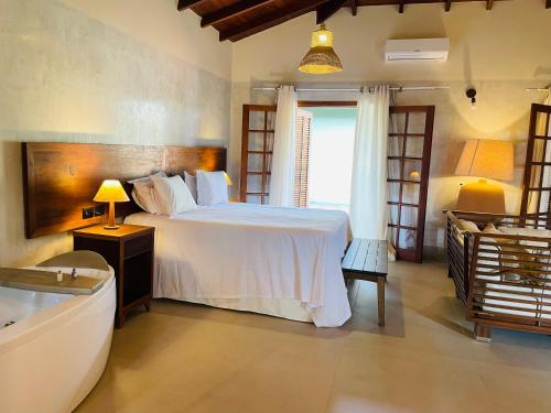 a bedroom with a bed and a tub in a room at Hiu Hotel in Juquei