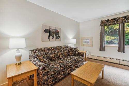 a living room with a couch and a table at Deluxe one bedroom suite located on first floor with outdoor heated pool 11517 in Killington