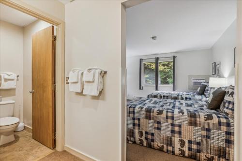 um quarto com uma cama e um WC em Deluxe one bedroom suite located on first floor with outdoor heated pool 11517 em Killington