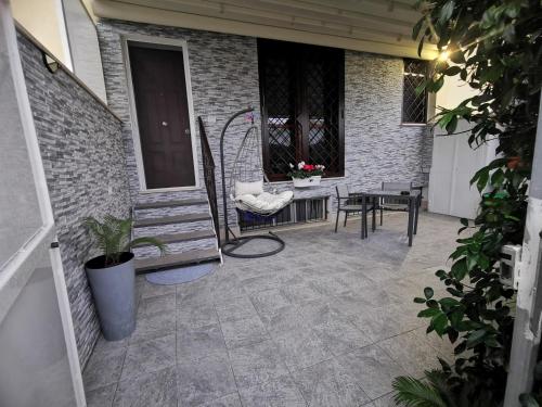 un patio con banco, mesa y sillas en Via Subiaco guest house, en Marco Simone