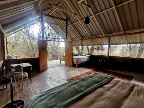 Habitación grande con cama y mesa. en The Tshilli Farm & Lodge en Maun