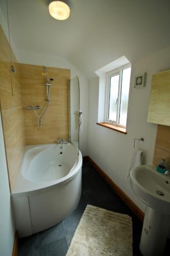 a bathroom with a large white tub and a sink at Brynhyfryd in Aberystwyth