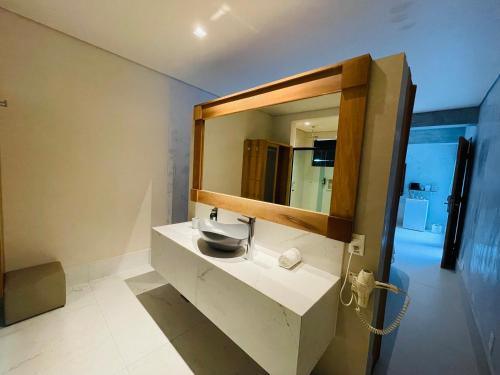 a bathroom with a sink and a mirror at Hiu Hotel in Juquei