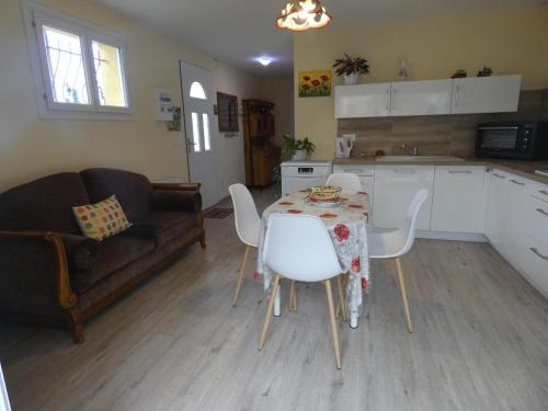 a kitchen with a table and chairs and a couch at Gite aux fleurs in Hagetmau