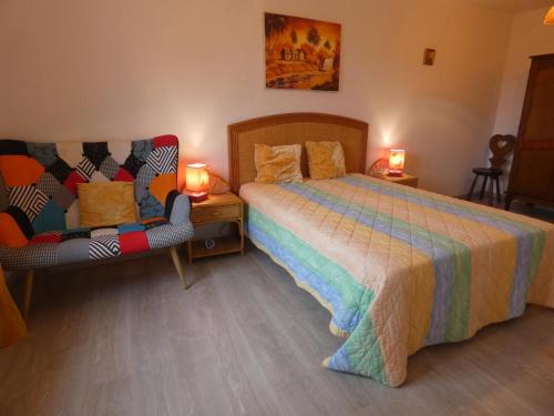 a bedroom with a bed and two chairs in it at Gite aux fleurs in Hagetmau