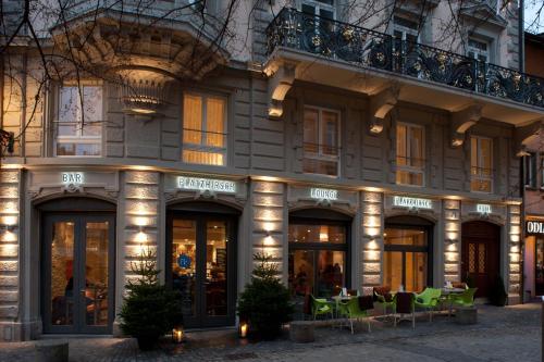 un bâtiment avec des tables et des chaises devant lui dans l'établissement Hotel Platzhirsch, à Zurich