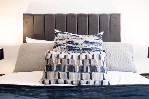 un letto con un cuscino bianco e blu di Glasgow City, Hydro Apartment a Glasgow