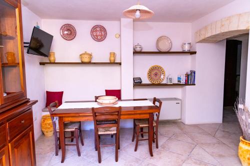 uma sala de jantar com uma mesa e cadeiras e pratos na parede em Masseria Caliani em Borgagne