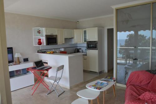 a kitchen and living room with a laptop on a table at Cozy cocoon with balcony close to the sea in Cannes