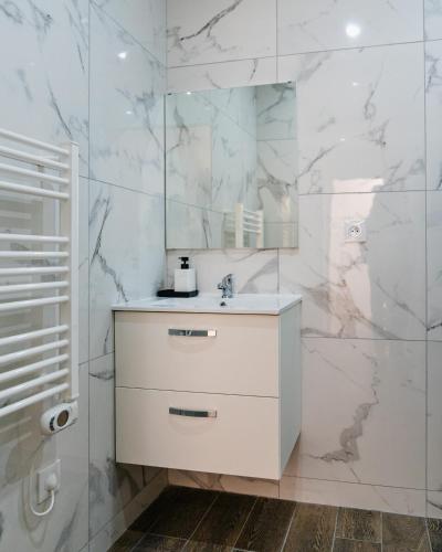 a white bathroom with a sink and a mirror at Studio Nicehome Massena in Nice