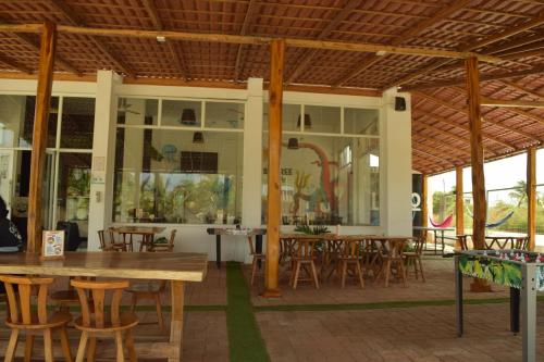 un restaurante con mesas y sillas de madera y ventanas en Ohana Beach Hotel en Playas