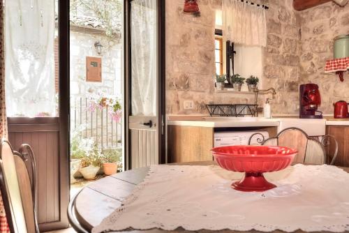 a red bowl sitting on a table in a kitchen at Case del Vicolo Stretto in Modica
