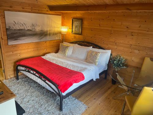 a bedroom with a bed with a red blanket at Chalet Free Sauna & Spa SuperKing bed in Killaloo