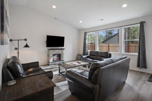 a living room with leather furniture and a fireplace at 172 Avocet home in Sunriver