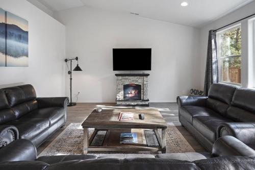 a living room with leather couches and a fireplace at 172 Avocet home in Sunriver