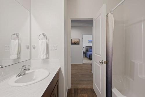 a white bathroom with a sink and a shower at 172 Avocet home in Sunriver