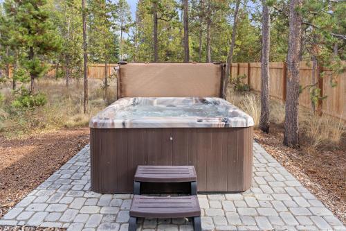 a hot tub and a bench in a backyard at 172 Avocet home in Sunriver