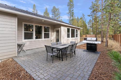 a patio with a table and chairs and a grill at 172 Avocet home in Sunriver