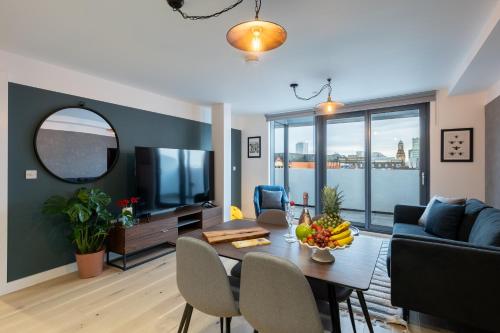 a living room with a table and a tv at Stay Kula Manchester - City Centre in Manchester