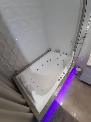 a white bath tub with purple lights in a bathroom at Apartamenty "PRZY KATEDRZE" GORZÓW - jacuzzi i klimatyzacja in Gorzów Wielkopolski