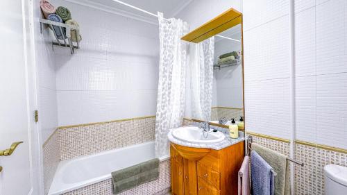 een badkamer met een wastafel, een toilet en een bad bij Apartamento Luz de Almoradi in Almoradí