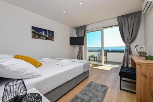 een slaapkamer met een bed en uitzicht op de oceaan bij Boutique Hotel IVY'Z in Novalja