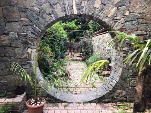 un arco en una pared de piedra en un jardín en Home-restaurant in Vanadzor, en Vanadzor
