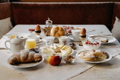 a table topped with plates of food and pastries at Hotel Pradell in Ortisei