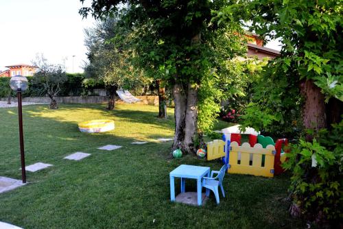 a yard with a playground with a tree and a table at Le Palme Sona in Sona