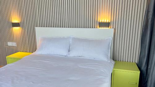 a bedroom with a white bed with two lights on the wall at Wadi Shab Beach Villa in Sur