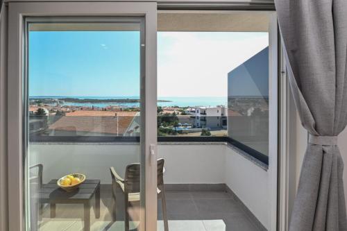 a balcony with sliding glass doors and a table with a view at Boutique Hotel IVY'Z in Novalja