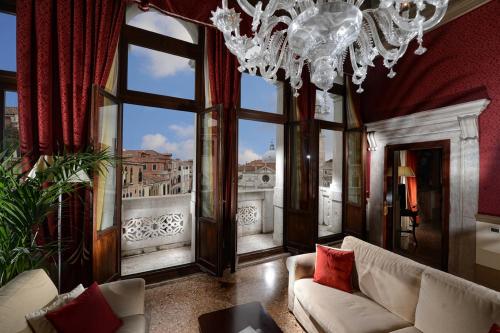 a living room with a chandelier and large windows at Ruzzini Palace Hotel in Venice