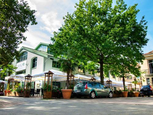 a car parked in a parking lot in front of a building at Minjo Hotel in Bad Kreuznach