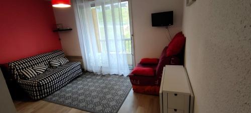 un salon avec un canapé et une chaise dans l'établissement Studio Cauterets centre - le Macadau, à Cauterets