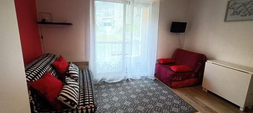 - un salon avec deux chaises et une fenêtre dans l'établissement Studio Cauterets centre - le Macadau, à Cauterets