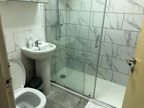 La salle de bains est pourvue de toilettes, d'un lavabo et d'une douche. dans l'établissement Tiffany’s, à Manchester