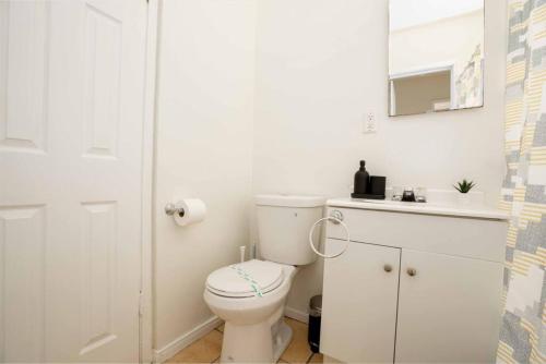 La salle de bains blanche est pourvue de toilettes et d'un lavabo. dans l'établissement Homey 1BR Home in Mid-City near K-town, à Los Angeles