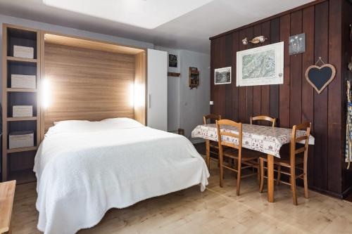 une chambre avec un lit, une table et des chaises dans l'établissement Studio - Le Vorasson Ideal for a duo break in Saint-Gervais!, à Saint-Gervais-les-Bains