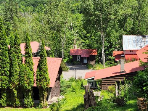 a house with a red roof next to a forest at Belleayre Lodge in Pine Hill